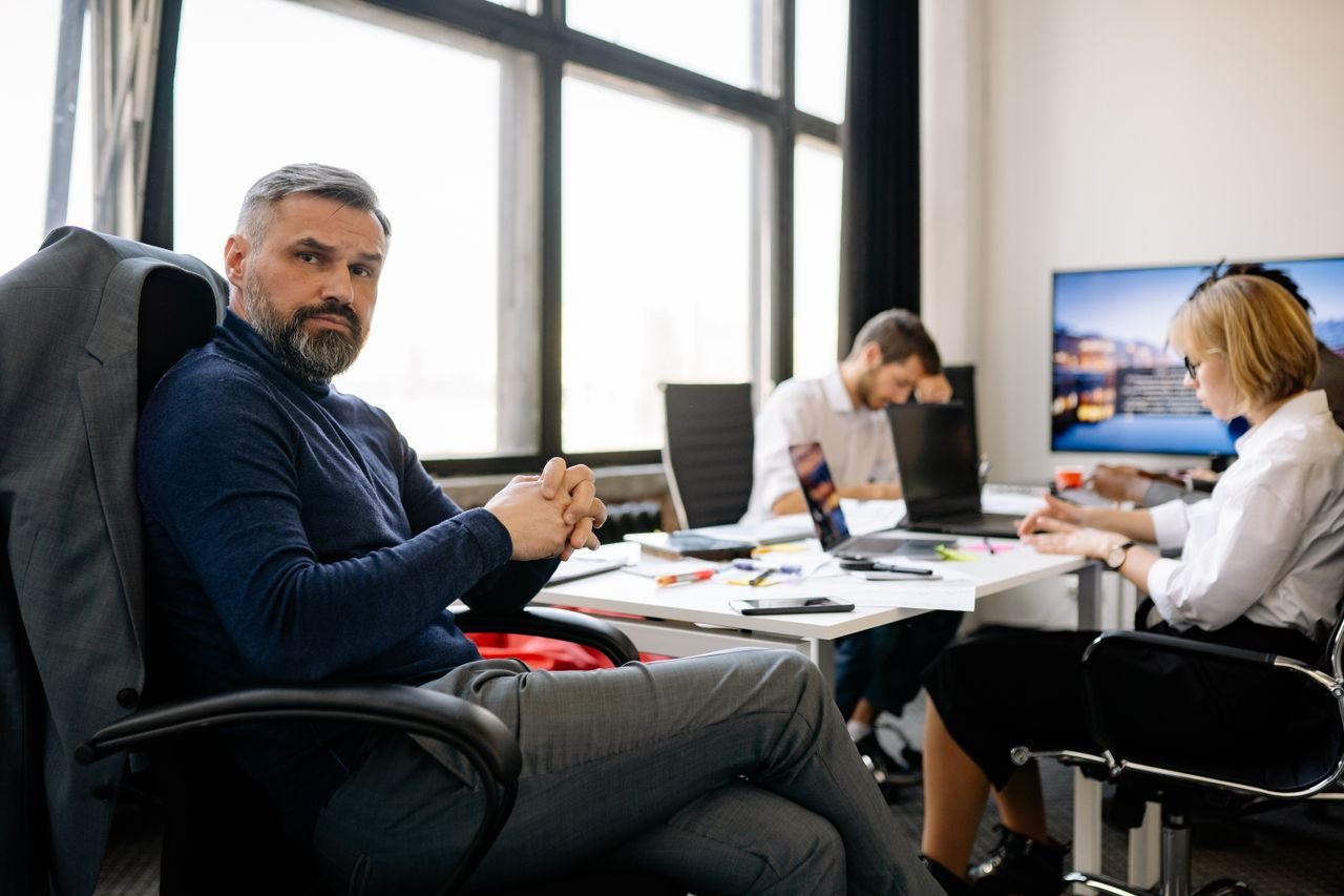 Co-workers engaging in a business discussion in a modern office setting.